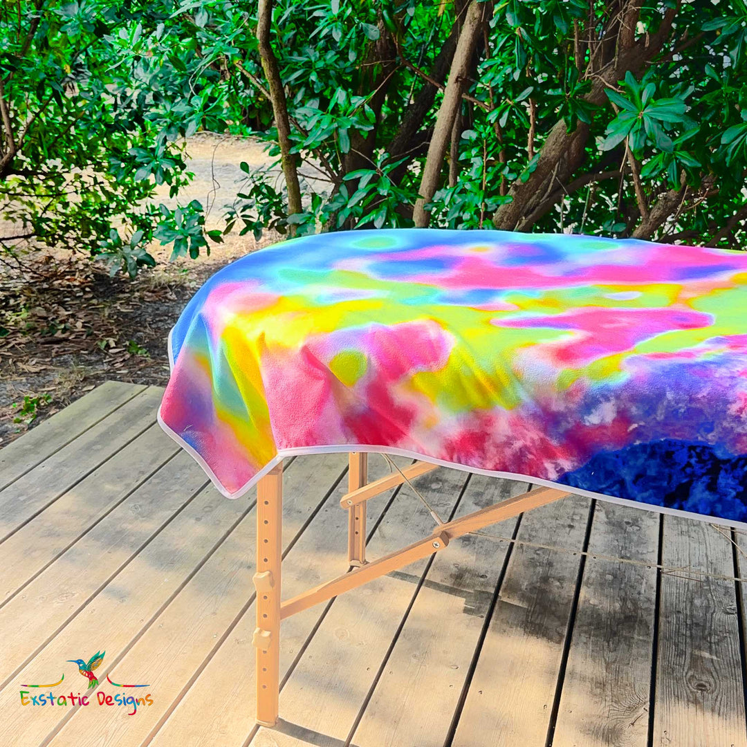 Détail de la serviette géante Tantra & Massage "Transe Minérale" sur une table de massage en extérieur, vue rapprochée des textures minérales iridescentes, création vibratoire de Xavier Gaillot pour Exstatic Designs.